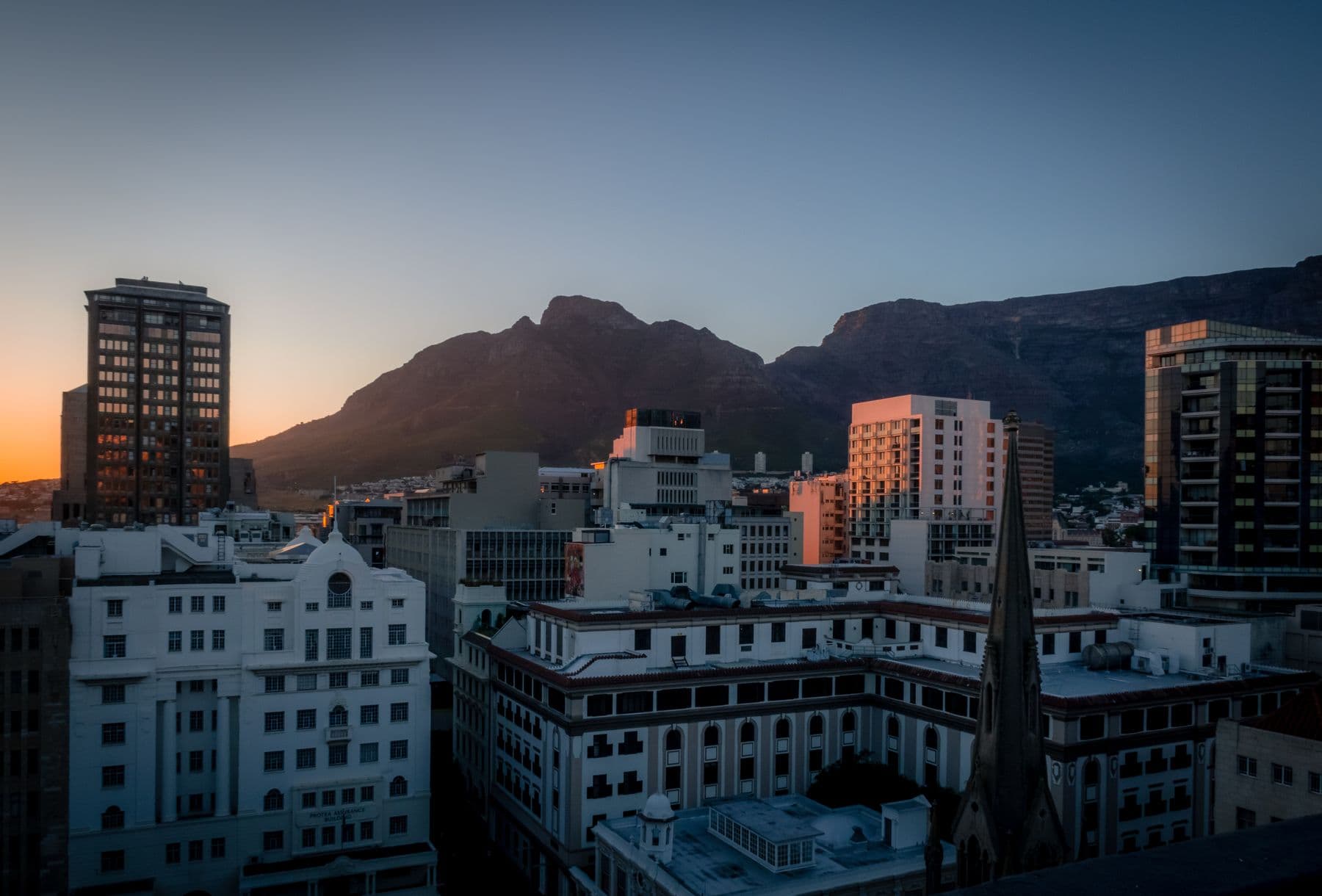 Cape Town at dusk, the city and mountain silhouetted against fading light